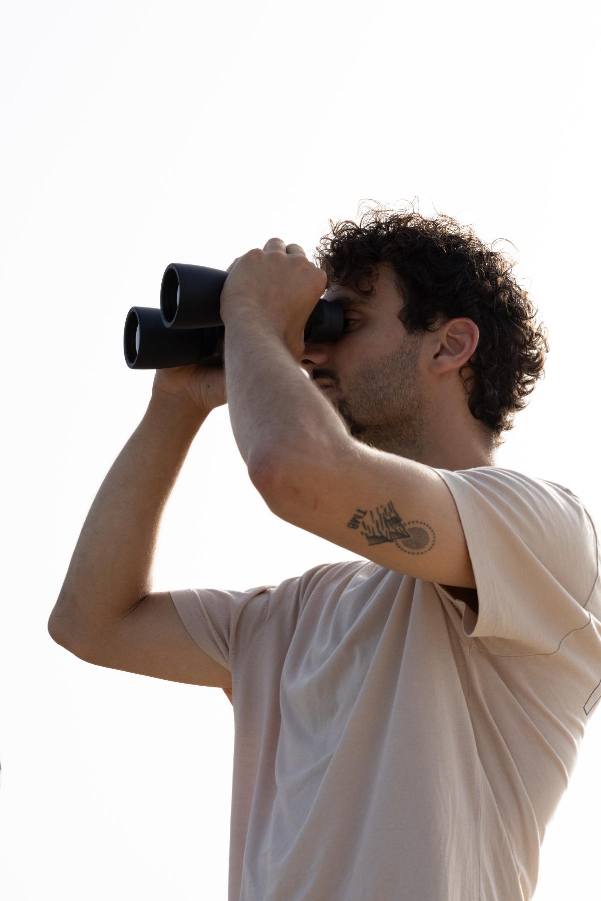 Team member scanning the horizon with binoculars